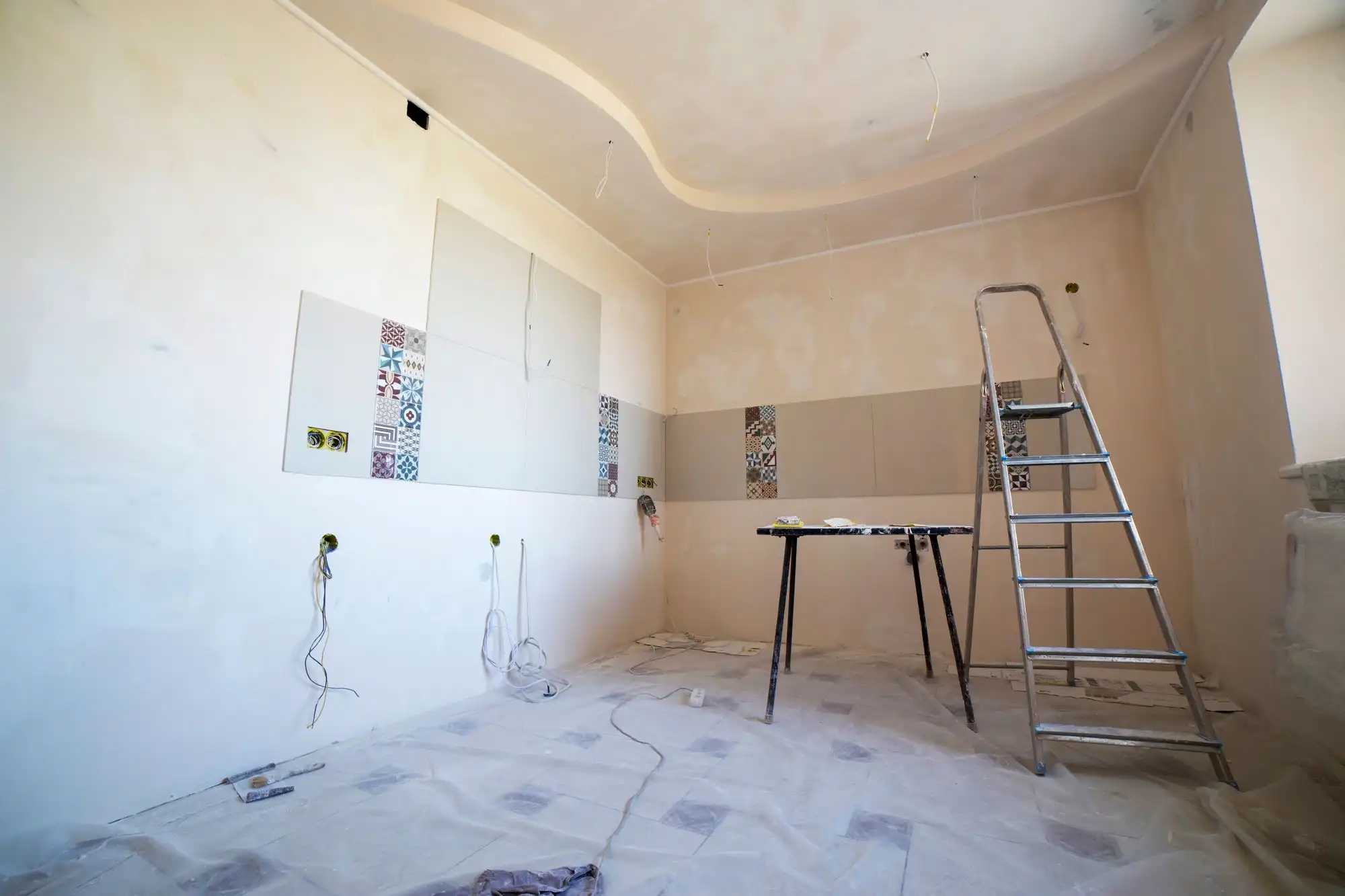 Remontuojamo buto kambarys su nuglaistytomis sienomis, kopėčiomis ir dengtomis grindimis